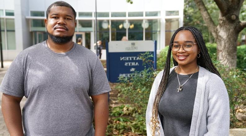 Two people stand in front of a building on ODU's campus.